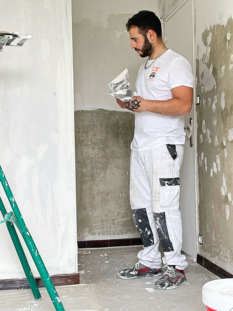 Ange Pastor, peintre en bâtiment, en préparation d'un mur